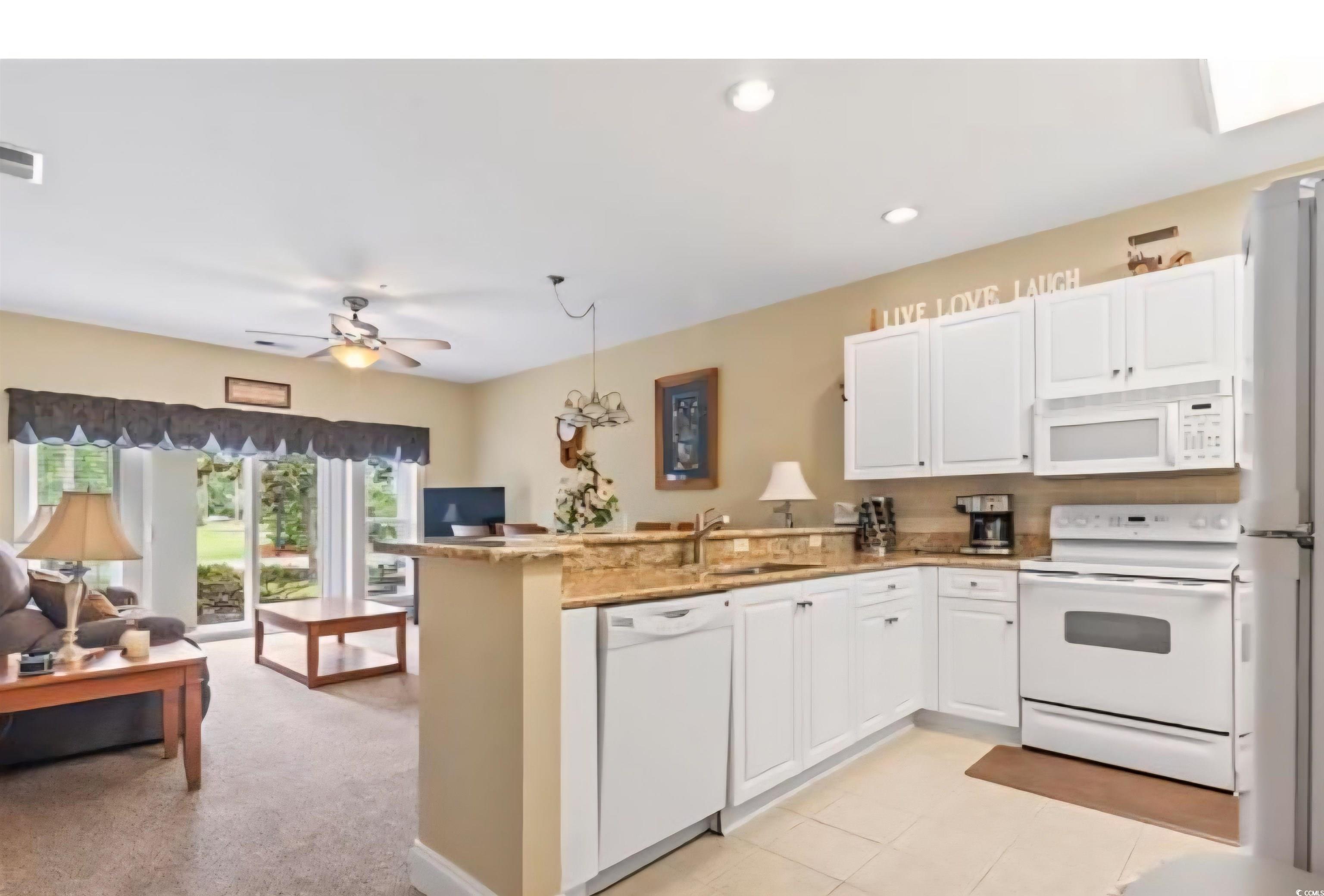 1009 World Tour Boulevard Myrtle Beach, SC 29579 - Photo 35 of 36 Kitchen with white appliances, a peninsula, pendant lighting, white cabinets, and open floor plan