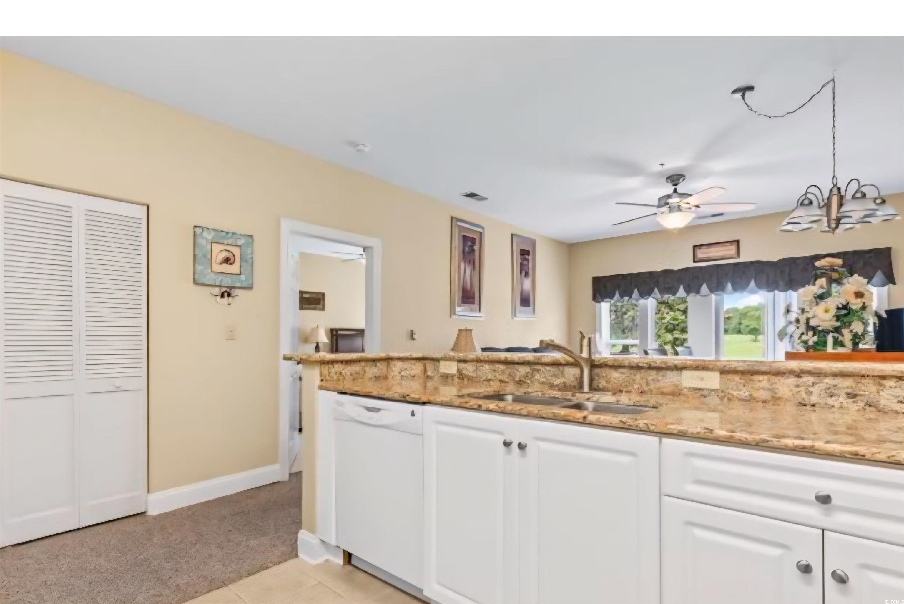 1009 World Tour Boulevard Myrtle Beach, SC 29579 - Photo 9 of 36 Kitchen featuring white cabinets, white dishwasher, light tile patterned floors, light stone countertops, and ceiling fan