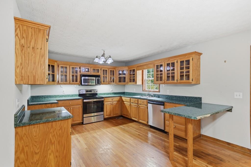 176 Big Oak Tree Road Northwest Adairsville, GA 30103 - Photo 18 of 77 a kitchen with stainless steel appliances granite countertop a stove a sink and a refrigerator