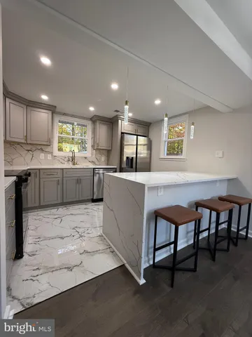 a kitchen with stainless steel appliances granite countertop a sink and a refrigerator
