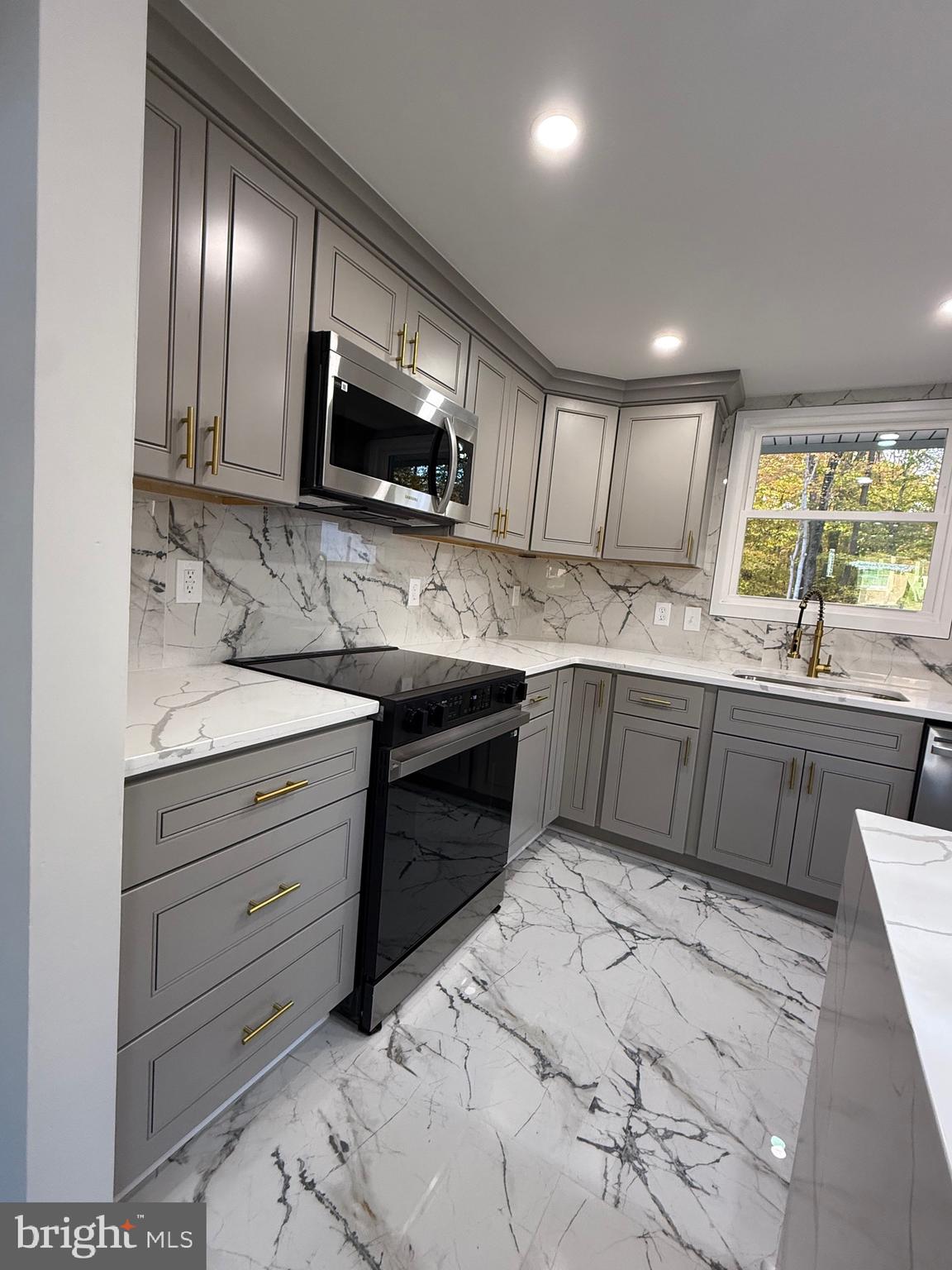 13014 Kerrydale Road Woodbridge, VA 22193 - Photo 23 of 53 a kitchen with stainless steel appliances kitchen island granite countertop a sink and a stove top oven with wooden floor