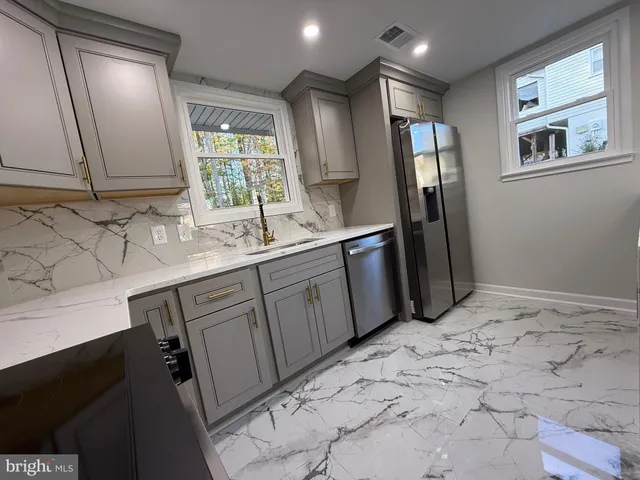 a large kitchen with kitchen island a sink table and chairs