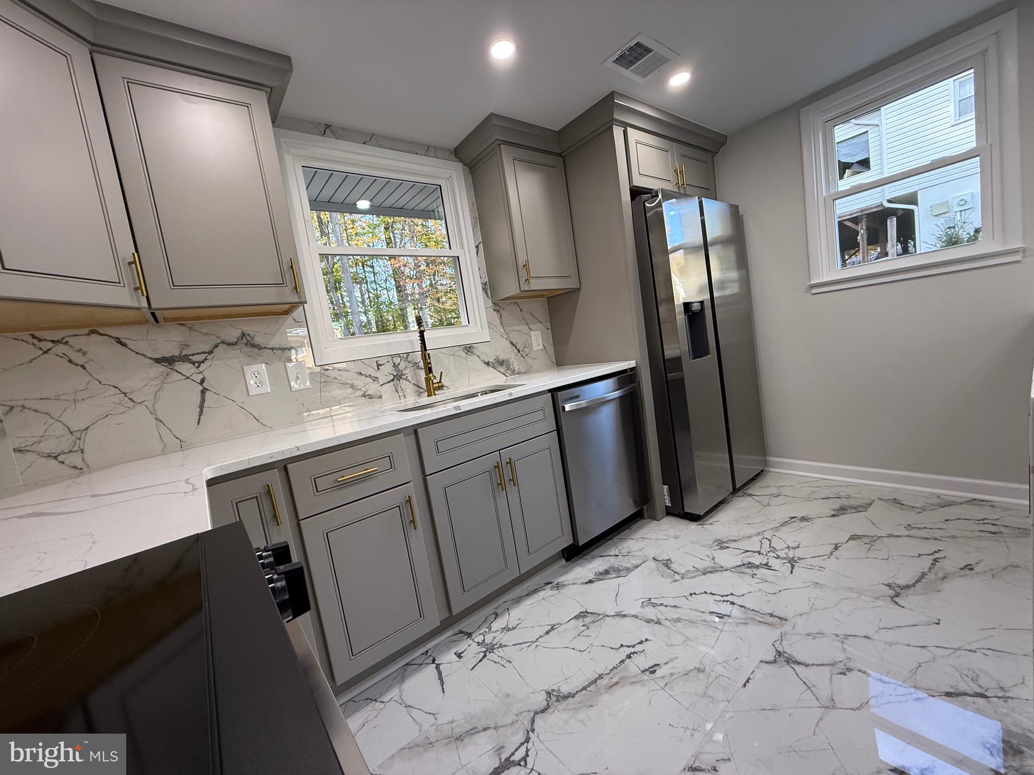 13014 Kerrydale Road Woodbridge, VA 22193 - Photo 27 of 53 a kitchen with stainless steel appliances a sink stove and refrigerator