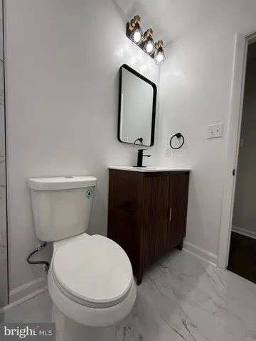 a bathroom with a toilet a sink and mirror
