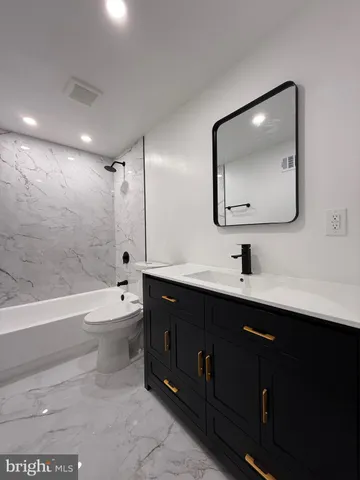 a bathroom with a toilet a sink and bathtub
