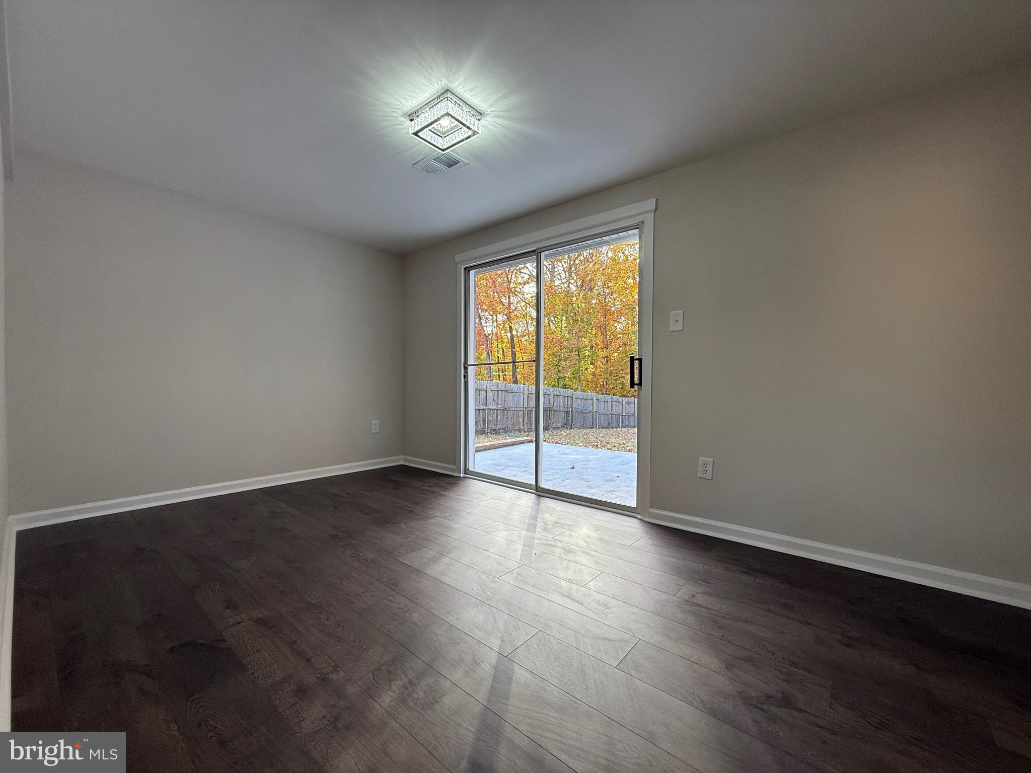 13014 Kerrydale Road Woodbridge, VA 22193 - Photo 50 of 52 an empty room with wooden floor and windows