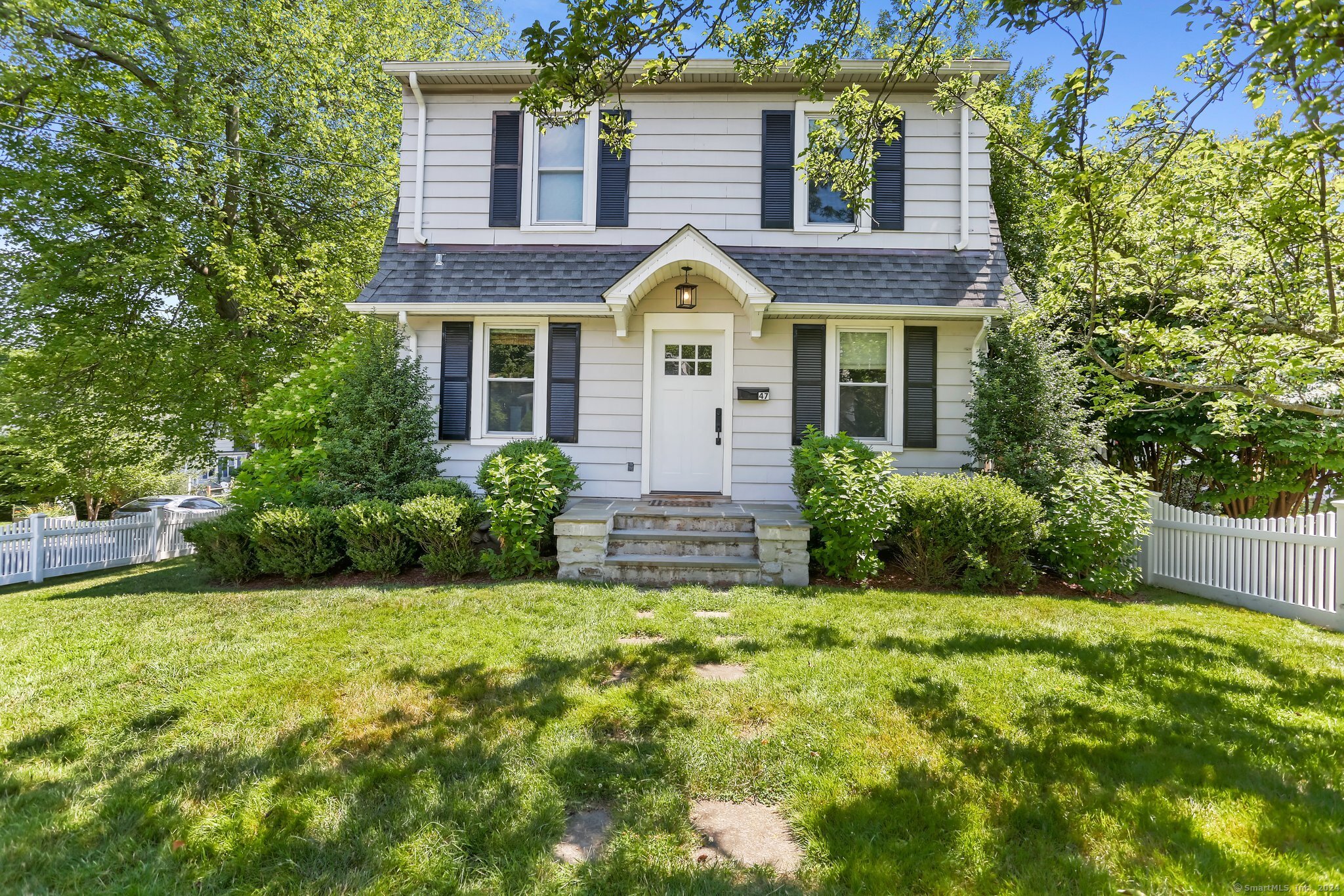 a view of a house with a yard and potted plants