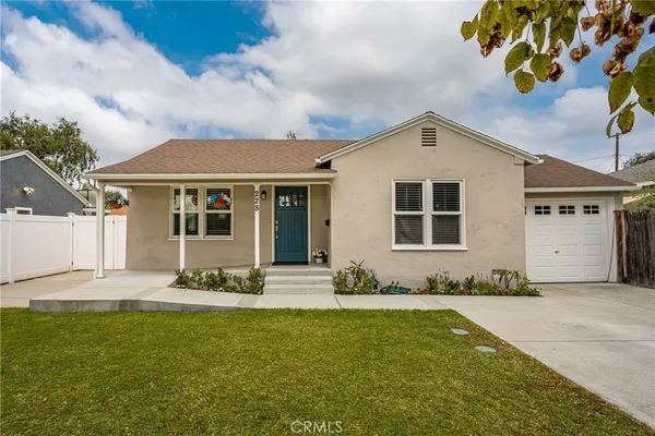 a front view of a house with a garden and yard
