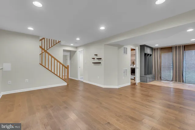 a view of an empty room with wooden floor