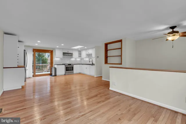 a view of an empty room with window and wooden floor