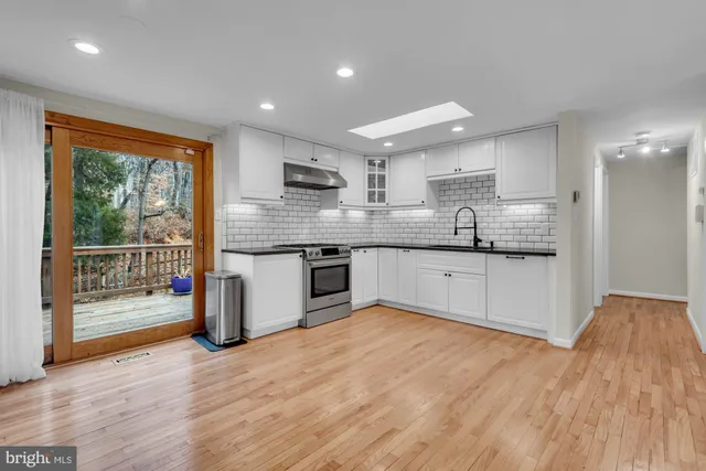 a large kitchen with stainless steel appliances granite countertop a stove a sink and a microwave