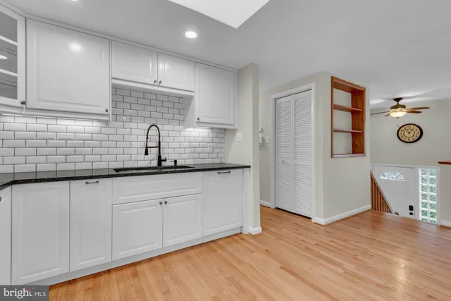 a kitchen with stainless steel appliances granite countertop a sink a stove a microwave and wooden floors