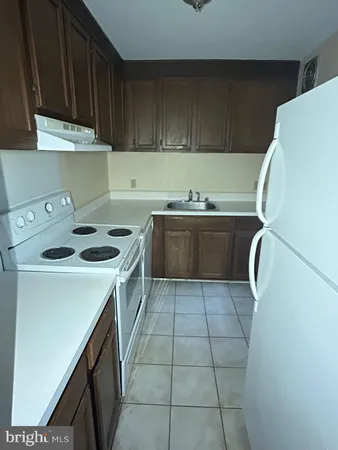 a kitchen with a sink a stove top oven and cabinets
