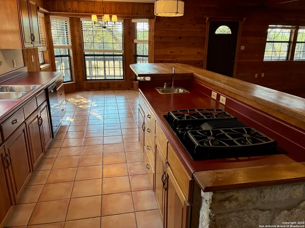 a kitchen with granite countertop a stove a sink and a shower