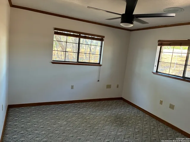 an empty room with a ceiling fan and window