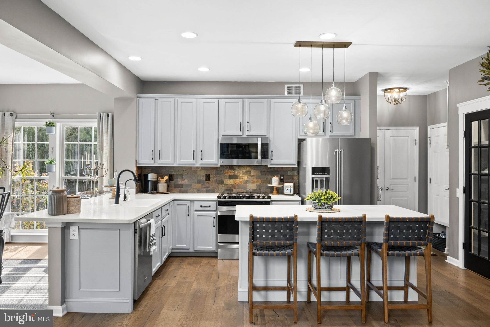 206 Sullivan Drive Mickleton, NJ 08056 - Photo 13 of 59 a kitchen with granite countertop a table chairs microwave and refrigerator