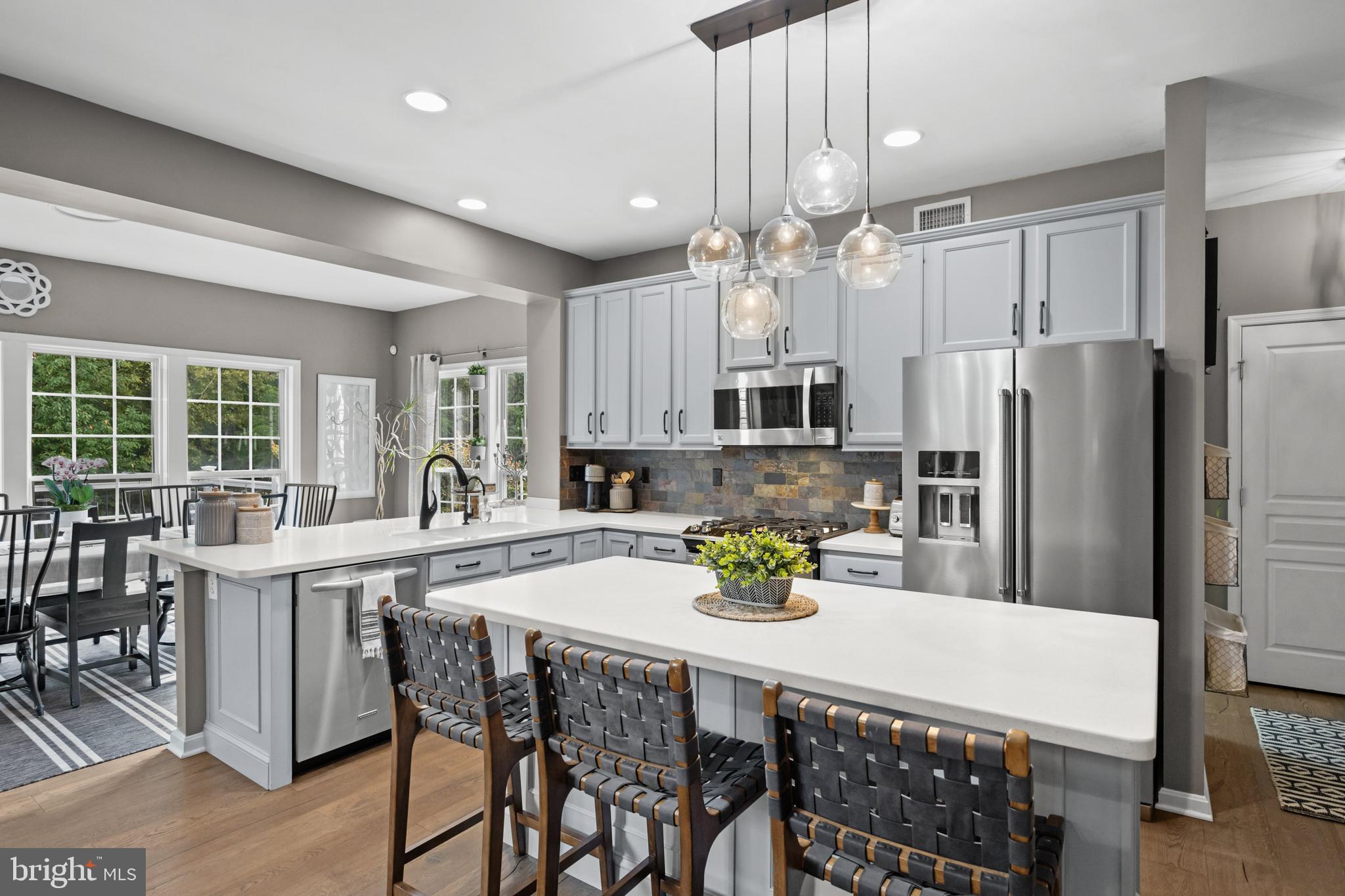 206 Sullivan Drive Mickleton, NJ 08056 - Photo 14 of 59 a kitchen with stainless steel appliances kitchen island granite countertop a dining table chairs and white cabinets