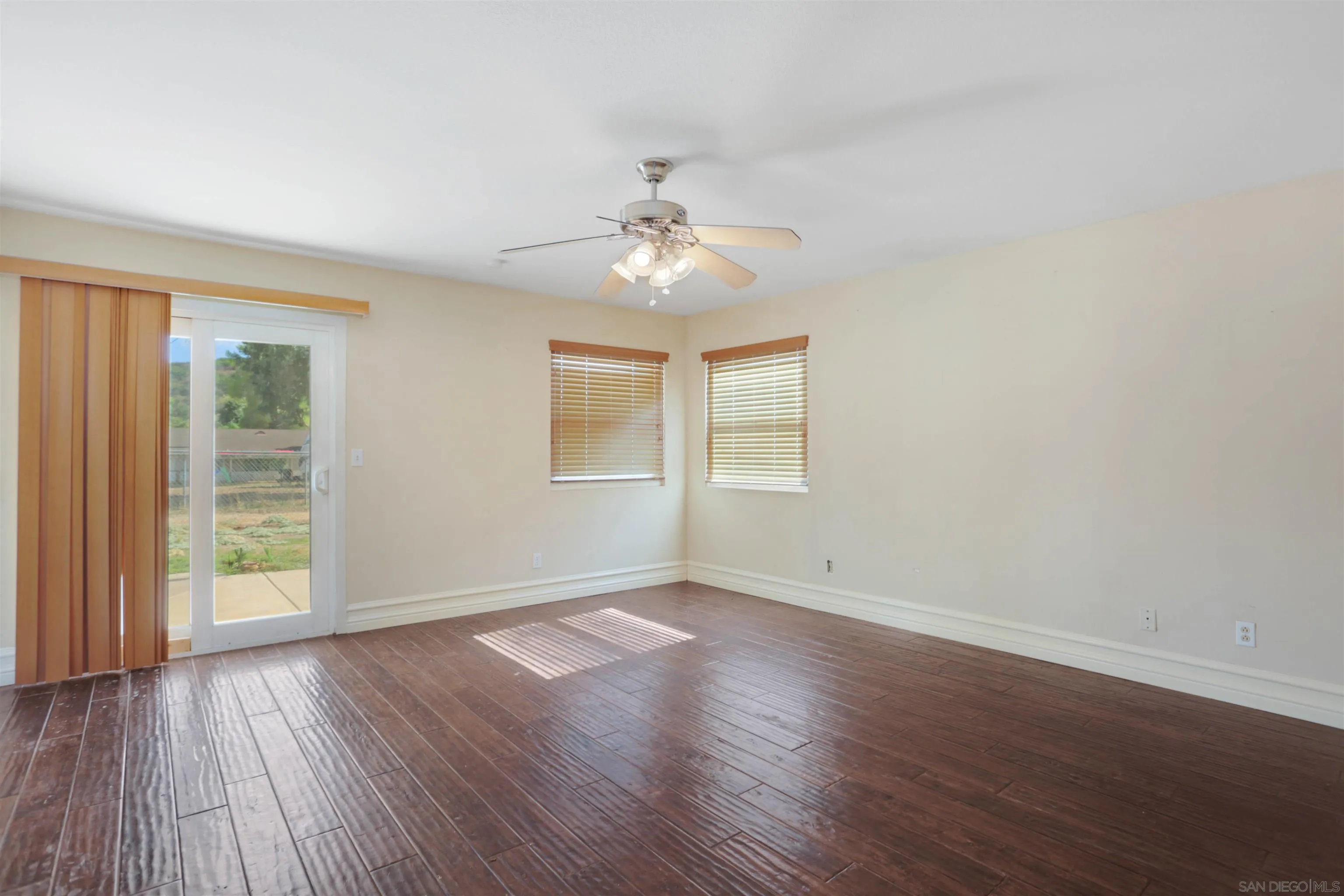 23641 Springwood Drive Ramona, CA 92065 - Photo 11 of 34 an empty room with wooden floor chandelier fan and windows