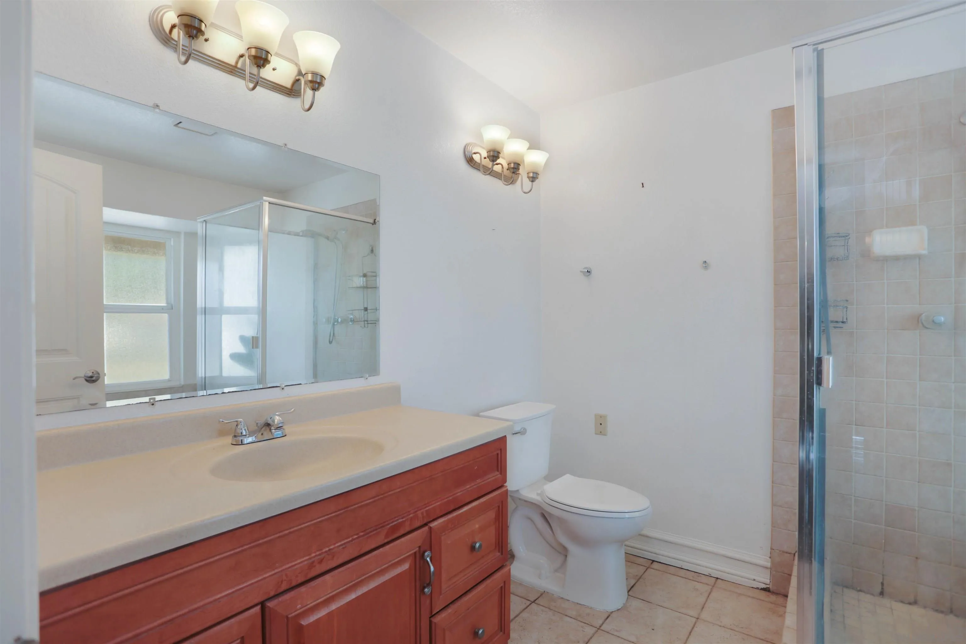 23641 Springwood Drive Ramona, CA 92065 - Photo 13 of 34 a bathroom with a toilet a sink a mirror and a shower