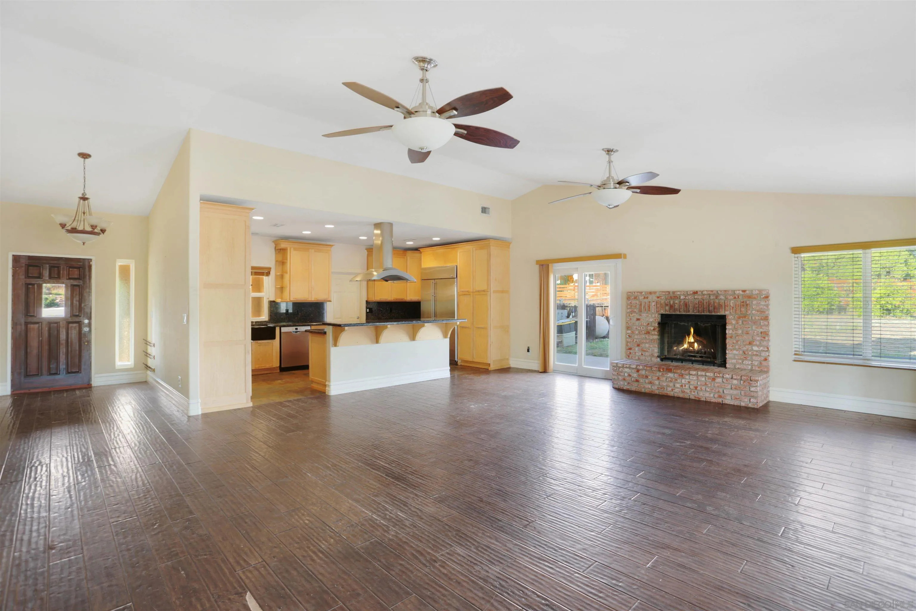 23641 Springwood Drive Ramona, CA 92065 - Photo 2 of 34 a view of a livingroom with a fireplace a ceiling fan and windows