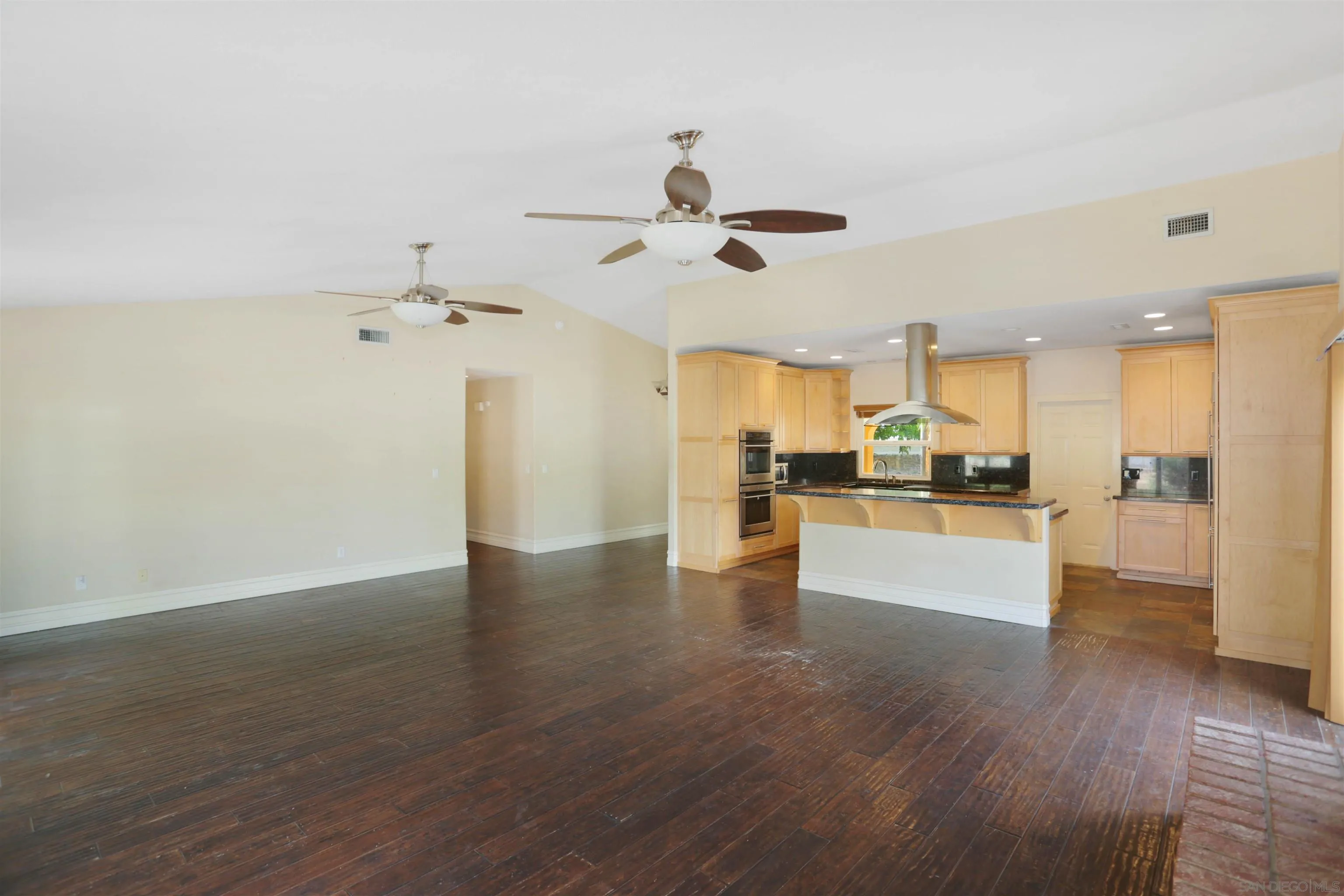 23641 Springwood Drive Ramona, CA 92065 - Photo 9 of 34 a view of a kitchen and an empty room with wooden floor
