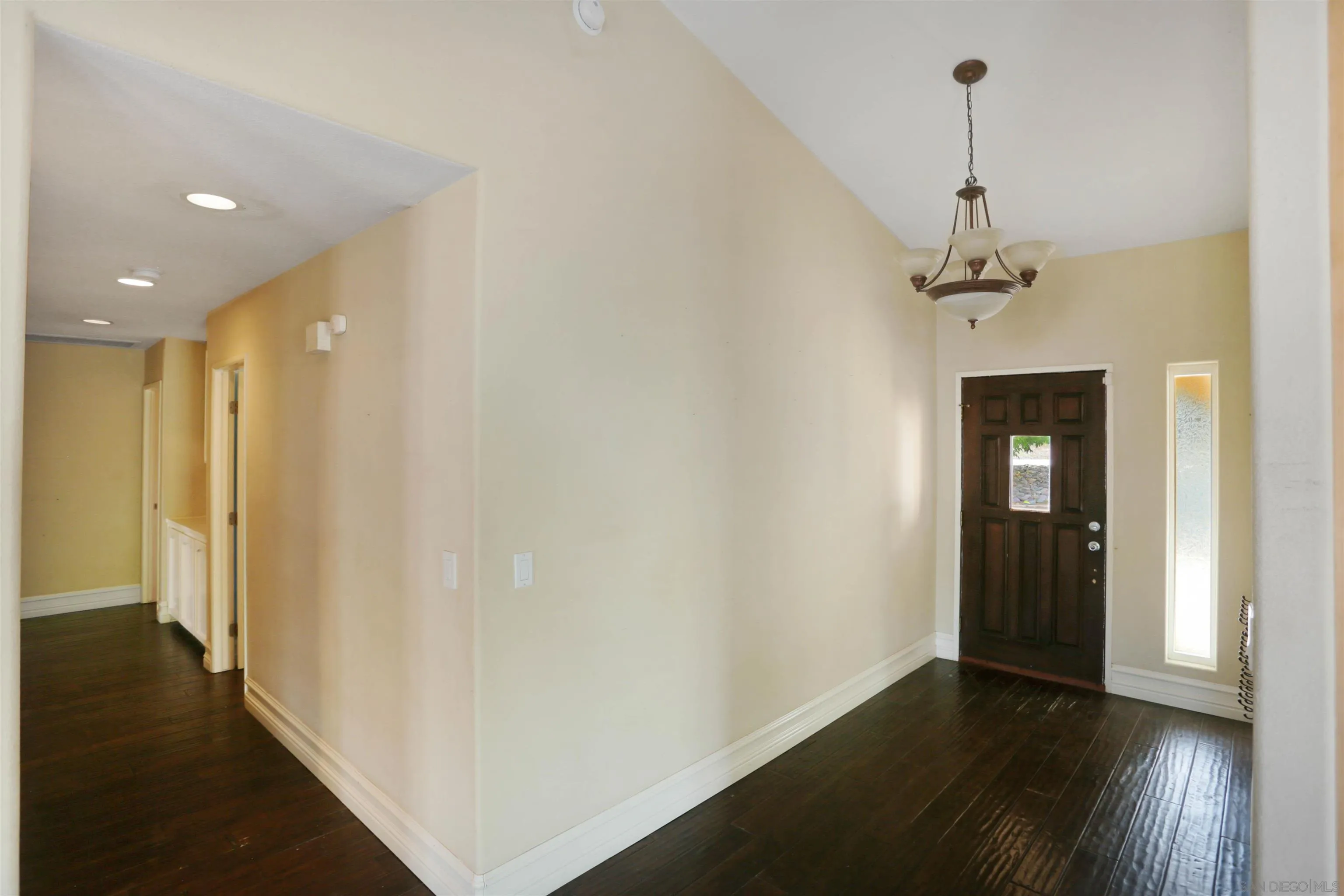 23641 Springwood Drive Ramona, CA 92065 - Photo 10 of 34 a view of a hallway with wooden floor and a chandelier
