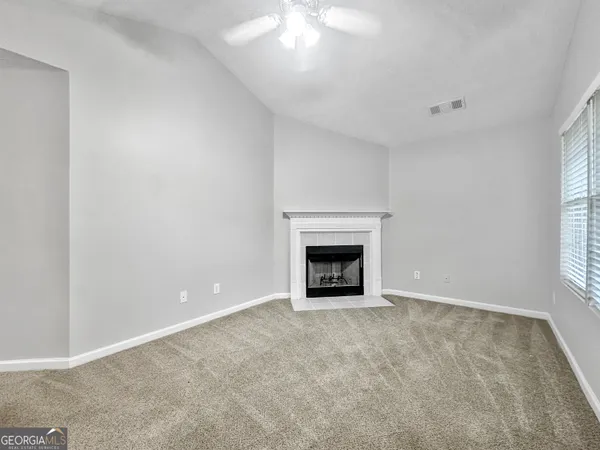 an empty room with a fireplace and window