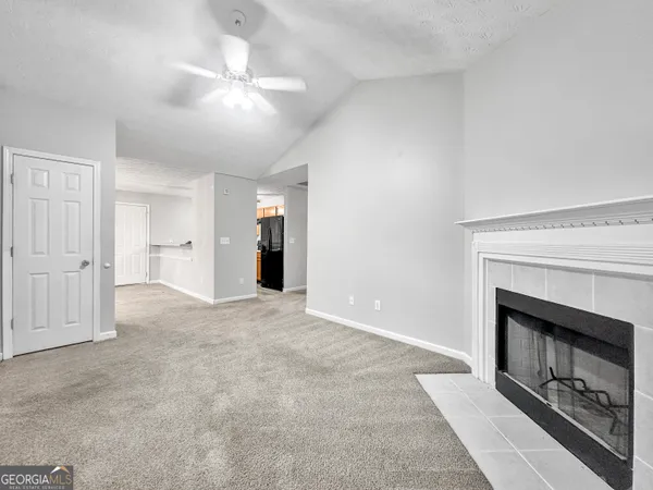 an empty room with a fireplace and fan