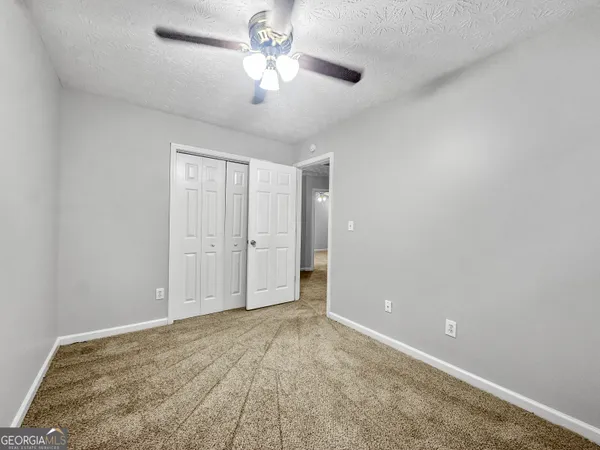 an empty room with a ceiling fan and a window