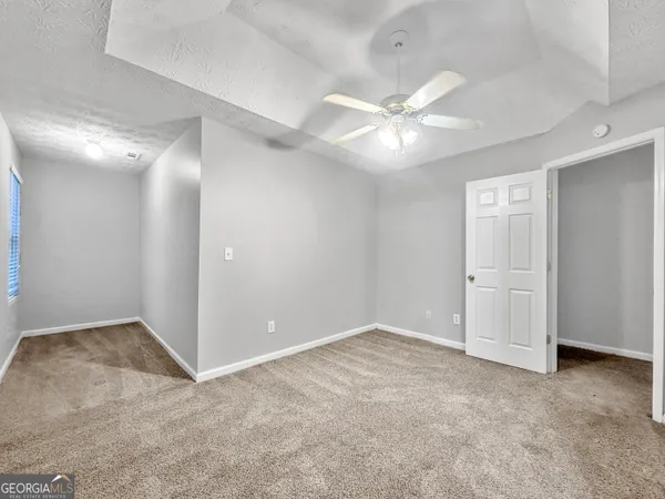 an empty room with closet and fan