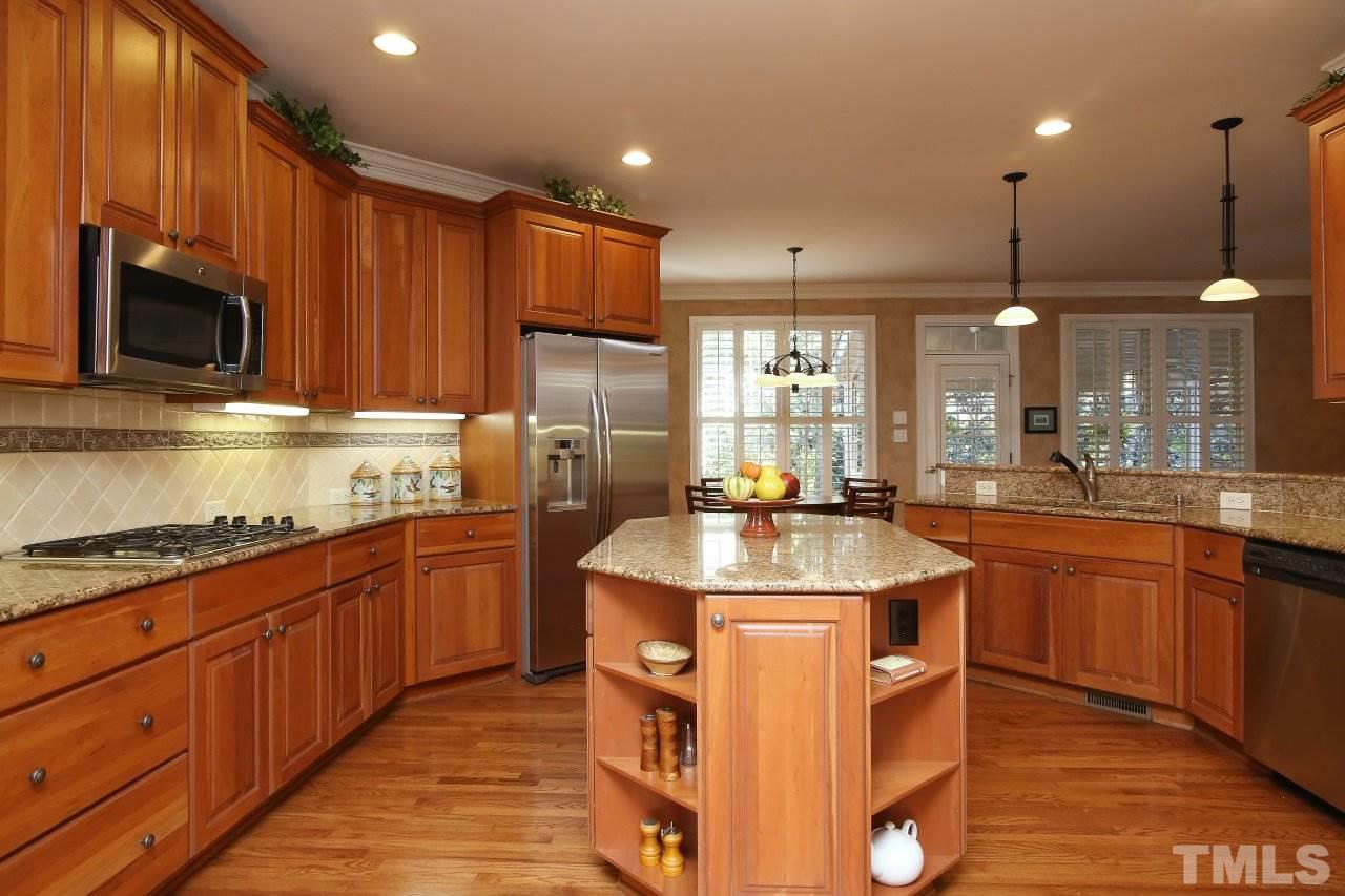 1841 Torrington Street Raleigh, NC 27615 - Photo 7 of 25 a kitchen with stainless steel appliances granite countertop a sink a stove and a refrigerator
