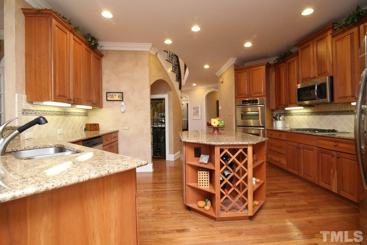 1841 Torrington Street Raleigh, NC 27615 - Photo 8 of 25 a kitchen with stainless steel appliances granite countertop a sink refrigerator and cabinets