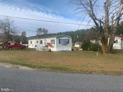 a front view of a house with a garden and trees