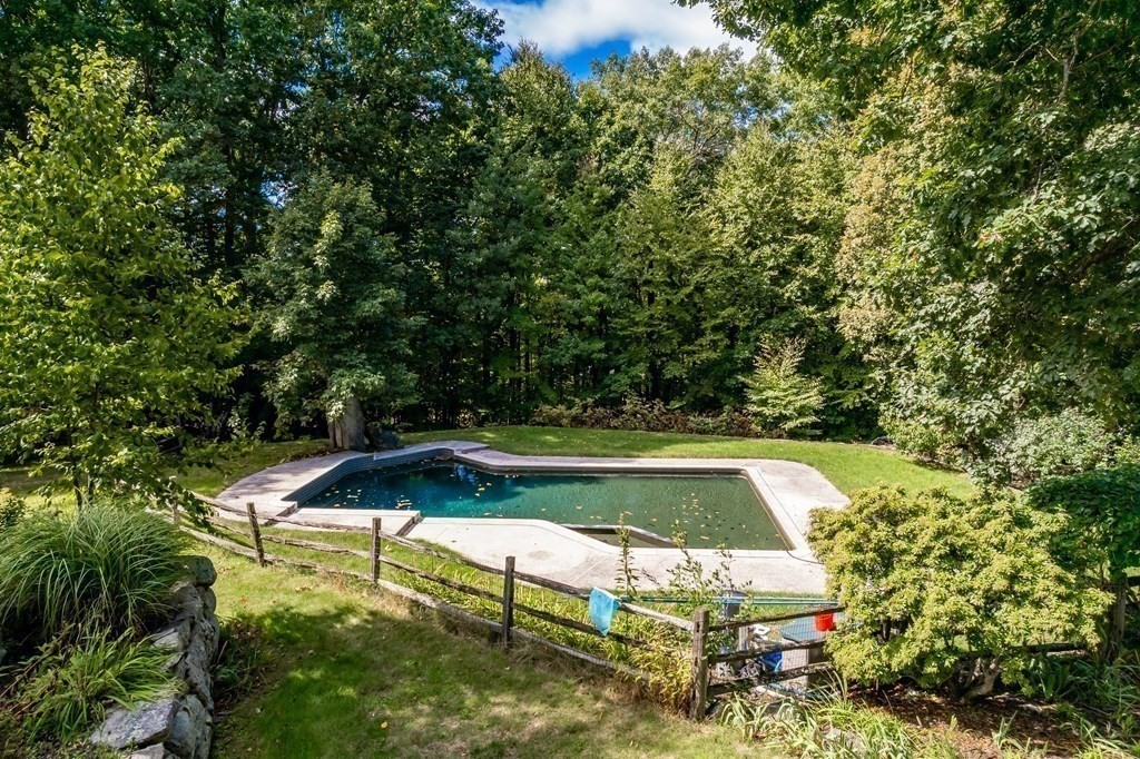 18 South Shaker Road Harvard, MA 01451 - Photo 26 of 36 a view of a swimming pool with lawn chairs under an umbrella