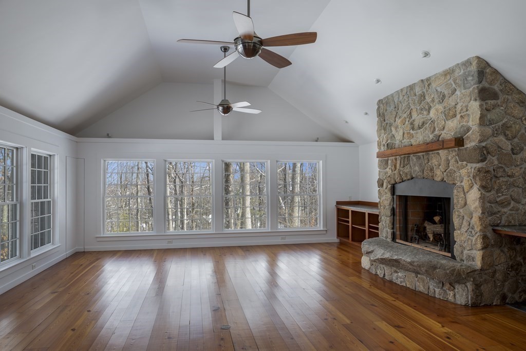 18 South Shaker Road Harvard, MA 01451 - Photo 7 of 36 an empty room with wooden floor fireplace cabinet and windows