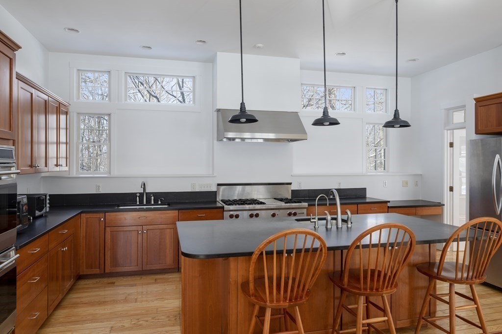 18 South Shaker Road Harvard, MA 01451 - Photo 10 of 36 a kitchen with stainless steel appliances granite countertop a sink a stove and chairs