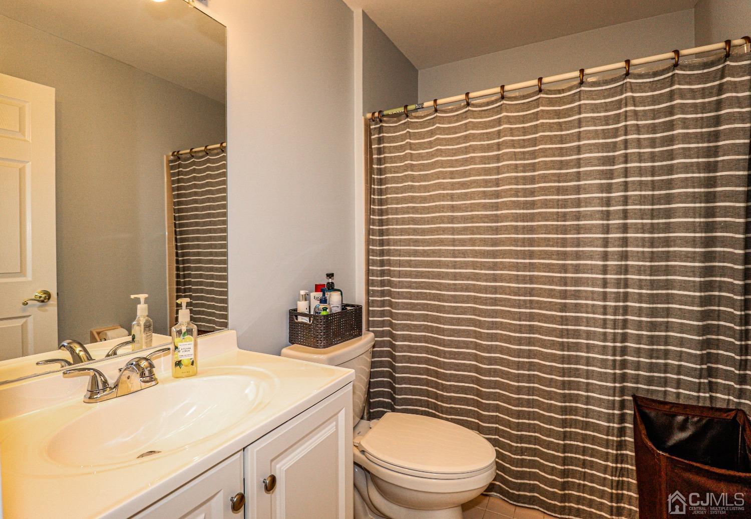 8 Prestwick Way Edison, NJ 08820 - Photo 22 of 27 a bathroom with a sink a toilet and shower curtain