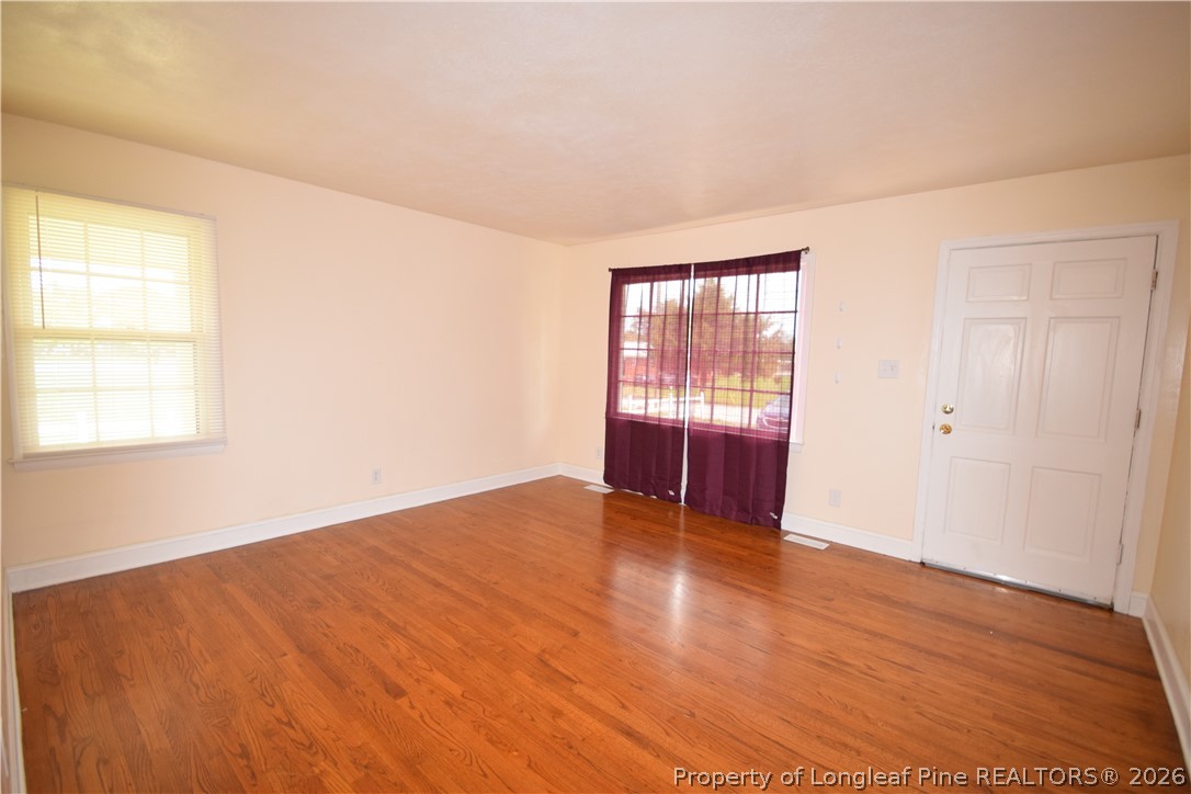 108 South 6th Street Spring Lake, NC 28390 - Photo 2 of 20 an empty room with wooden floor and windows