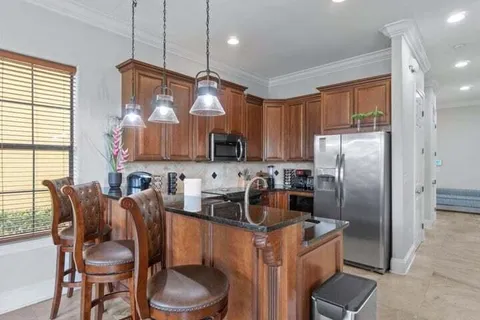 a kitchen with stainless steel appliances a refrigerator a sink a stove and cabinets