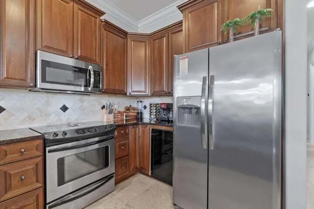 a kitchen with stainless steel appliances granite countertop a stove a refrigerator and a microwave