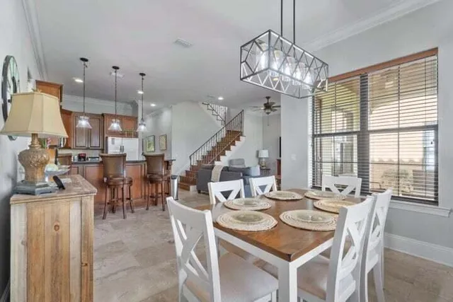 a dining table chairs and a chandelier