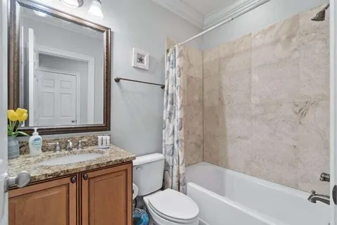 a bathroom with a granite countertop sink toilet and shower