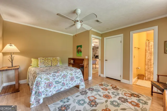 a view of a wooden house with a big yard and large trees