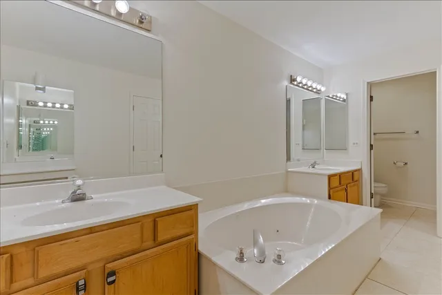 a bathroom with a tub a sink and mirror