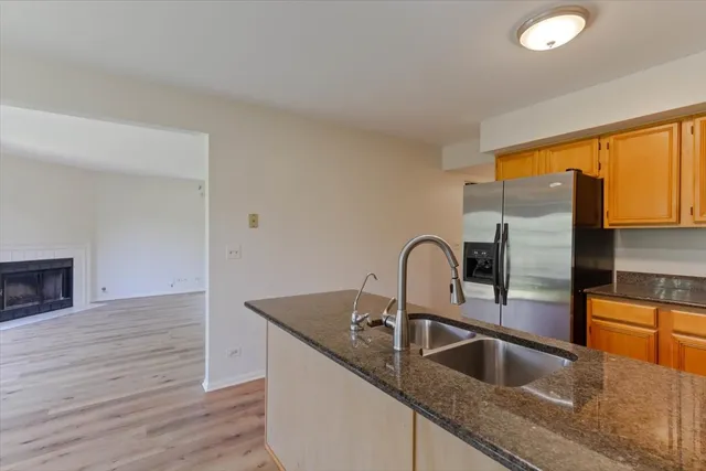 a kitchen with stainless steel appliances granite countertop a sink and a wooden floor