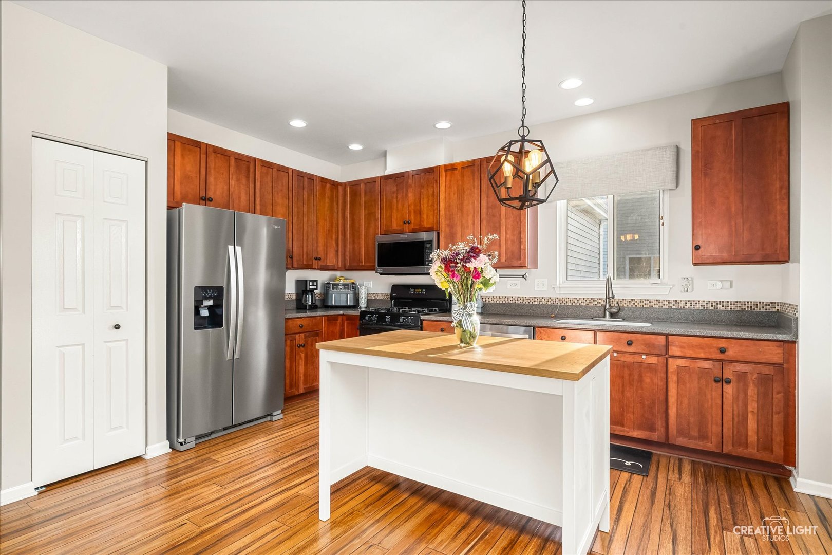 2455 Montclair Lane Montgomery, IL 60538 - Photo 3 of 22 a kitchen with stainless steel appliances granite countertop a refrigerator a sink dishwasher a stove and white countertops with wooden floor