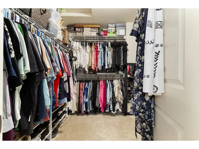 a view of walk in closet with clothes and shoes