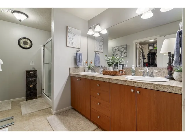 a bathroom with a sink double vanity granite and a shower