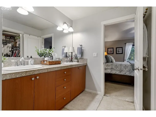 a en suite bathroom with a double vanity sink a large mirror and a shower