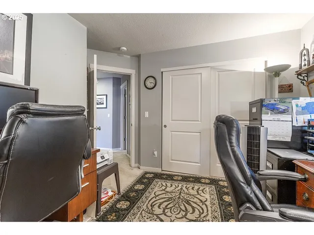 a living room with furniture a flat screen tv and a refrigerator